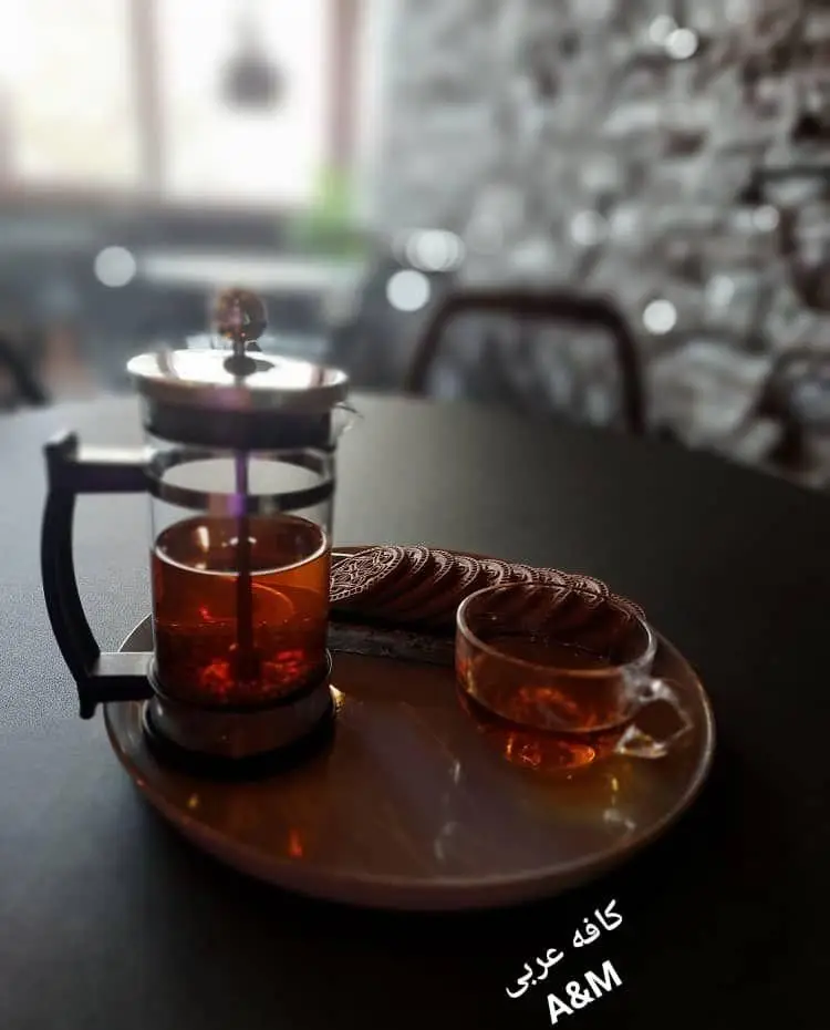 پذیرایی دلنشین چای و کوکی در کافه قلیان عربی A&M با فرنچ پرس و فنجان چای، فضایی آرامش‌بخش و دنج برای مشتریان.