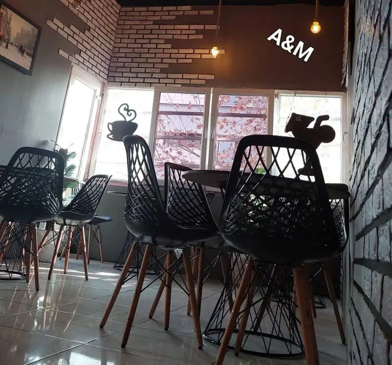 کافه A&M، کافه قلیان عربی با دکوراسیون شیک، صندلی‌های مدرن، دیوارهای آجری، نورپردازی خاص و پنجره‌های بزرگ، فضایی آرامش‌بخش.