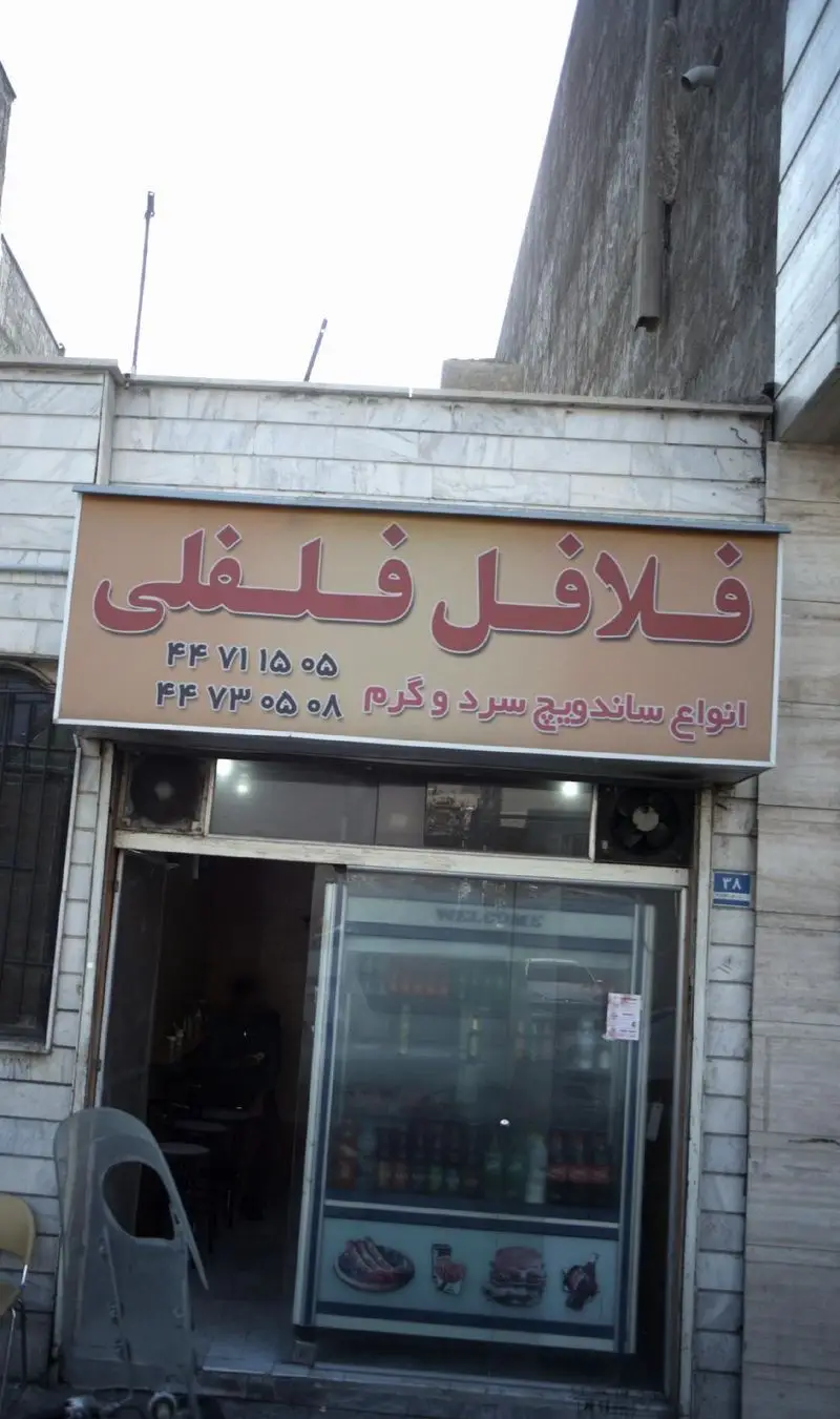فلافل فلفلی: تابلوی یک فست فود در تهران با ساندویچ‌های سرد و گرم و شماره تلفن‌های ۴۴ ۷۱ ۱۵ ۰۵ و ۴۴ ۷۳ ۰۵ ۰۸.