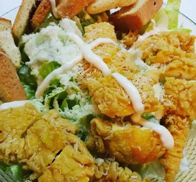 سالاد سزار مرغ سوخاری خوشمزه با نان تست، پنیر پارمزان و سس مخصوص کافه رستوران شهرزاد. بهترین انتخاب برای یک وعده لذیذ.