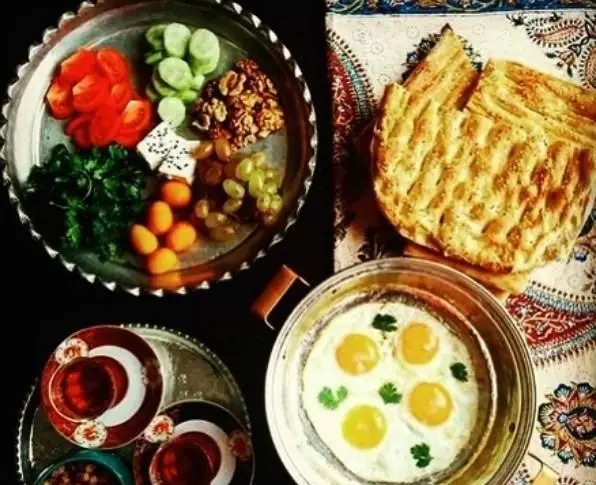 صبحانه سنتی و متنوع کافه رستوران دوذوقه: نان داغ، نیمرو، پنیر، سبزی، گوجه، خیار، گردو، میوه و چای ایرانی.