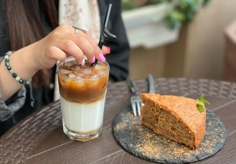 لذت نوشیدن لاته یخی خنک و چشیدن کیک تازه و خوشمزه در کافه اوان. بهترین انتخاب برای یک عصرانه دلپذیر و آرام.