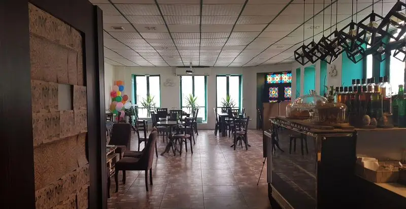 فضای داخلی کافه قنادی بامداد با دکوراسیون مدرن و میز و صندلی‌های چوبی، محیطی دلنشین برای نوشیدنی و شیرینی.