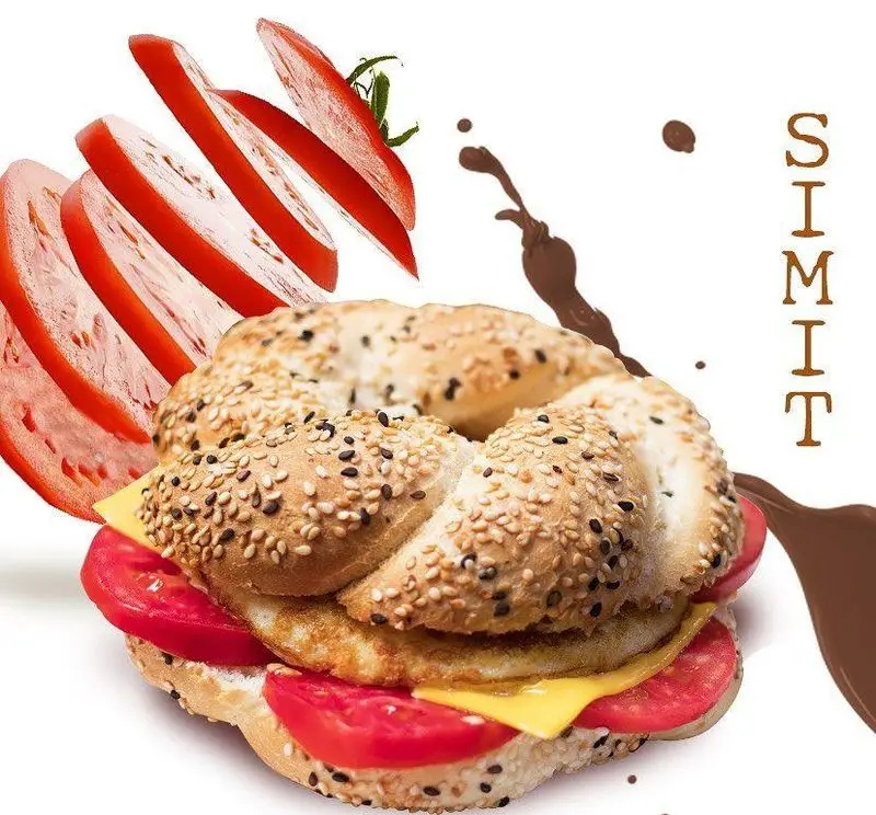 تصویر سیمیت معروف کافه ویونا با نان کنجدی، پر از گوجه فرنگی تازه، پنیر و محتویات لذیذ، گزینه‌ای دلچسب برای شروع روز یا عصرانه.