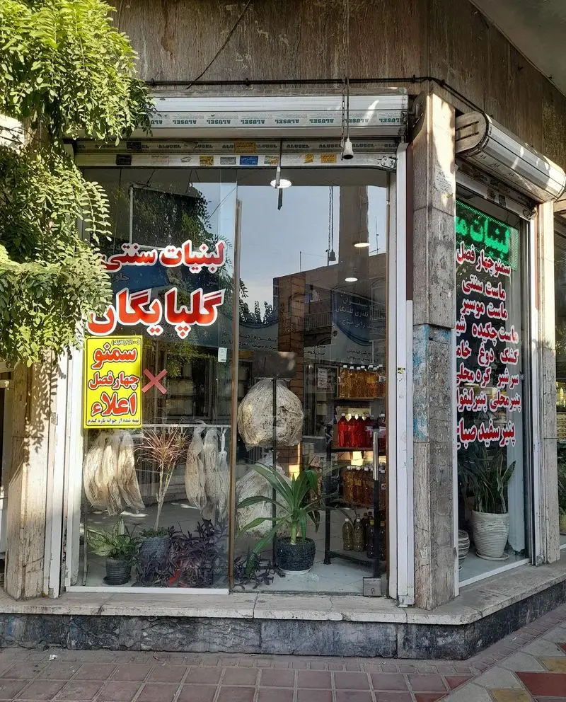 نمای بیرونی مغازه لبنیات سنتی گلپایگان، با ویترین شیشه‌ای متنوعی از محصولات محلی و سنتی شامل ماست، پنیر، کشک و روغن