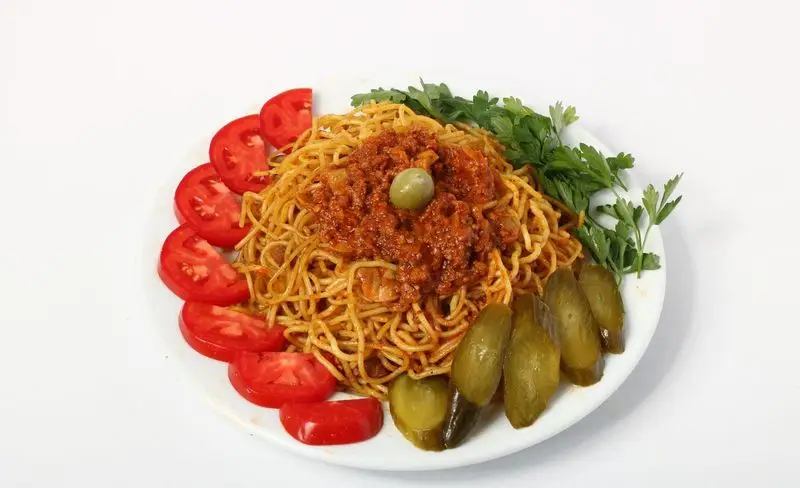 ماکارونی اسپگتی با سس گوشت غلیظ و زیتون، همراه گوجه فرنگی تازه، جعفری و خیارشور. غذای خوش طعم تهیه غذای تایماز برای سفارش.