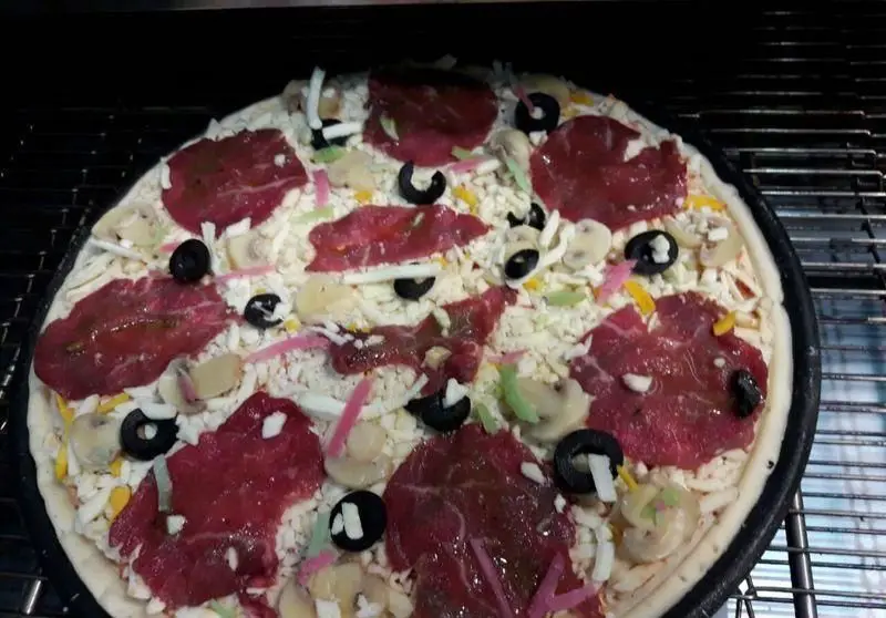 پیتزا شورینه آماده طبخ، با ترکیبی لذیذ از گوشت ورقه‌ای، پنیر موزارلا، قارچ تازه، زیتون سیاه و فلفل‌های رنگی. یک وعده خوشمزه از فست فود شورینه.