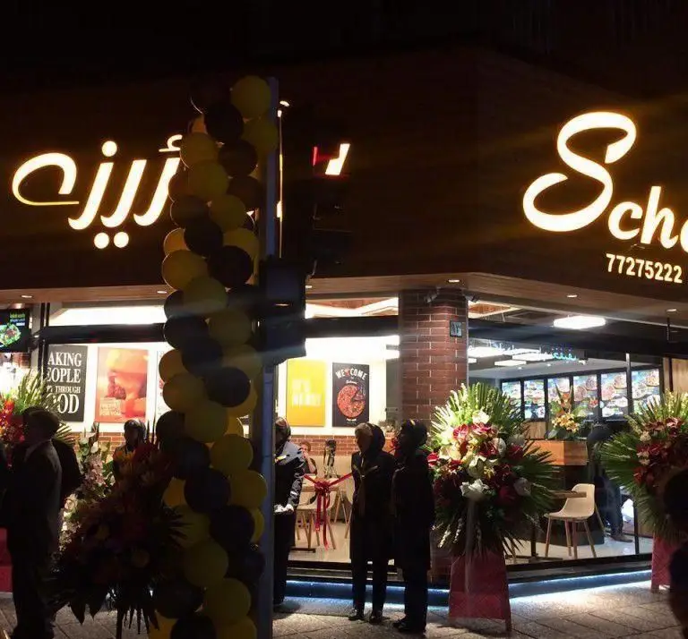 فست فود شورینه، نمای شبانه یک رستوران جدید در حال افتتاح با بادکنک آرایی و دسته گل برای خوش آمد گویی به مشتریان.