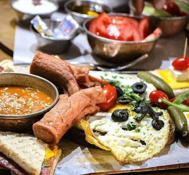 صبحانه کامل و لذیذ کافه رستوران داریما شامل املت، سوسیس، لوبیا، ساندویچ، زیتون و مخلفات تازه برای تجربه‌ای بی‌نظیر.