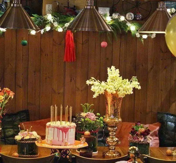 فضای دلنشین کافه رستوران داریما با دکوراسیون خاص جشن، نورپردازی گرم، گل‌آرایی زیبا و کیک تولد شیک و مدرن.