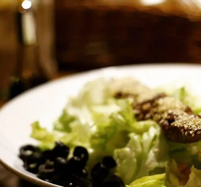 سالاد تازه و سالم کافه رستوران داریما با کاهو، زیتون سیاه و تکه‌های پروتئینی با کنجد، انتخابی عالی برای وعده‌ای سبک و مغذی.