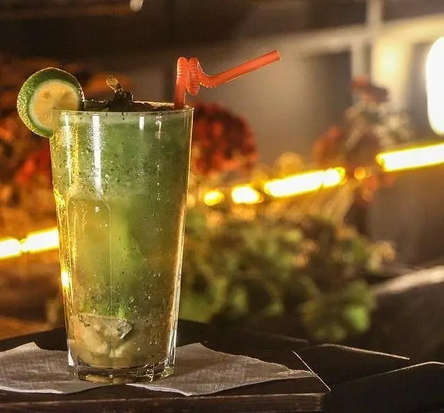 موهیتو تازه و خنک با برش لیمو و نعناع در لیوان بلند، انتخابی ایده‌آل در کافه رستوران داریما برای لحظات دلپذیر شما.