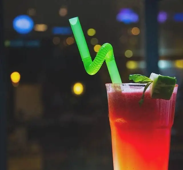 نوشیدنی رنگارنگ و خنک کافه رستوران داریما با نی سبز و تزیین خیار و نعناع، ایده‌آل برای یک شب تابستانی دلنشین و تجربه‌ای لذیذ.