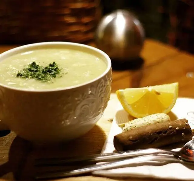 کرم سوپ خوشمزه و تازه با تزئین سبزیجات معطر، همراه لیمو و نان برشته در کافه رستوران داریما. انتخابی عالی برای یک وعده دلپذیر.