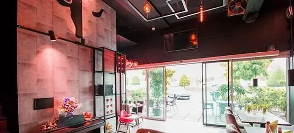 دکوراسیون داخلی مدرن و شیک رستوران فرنگی قالوس با نورپردازی زیبا، میز و صندلی‌های راحت و پنجره‌های بزرگ رو به فضای سبز بیرونی.