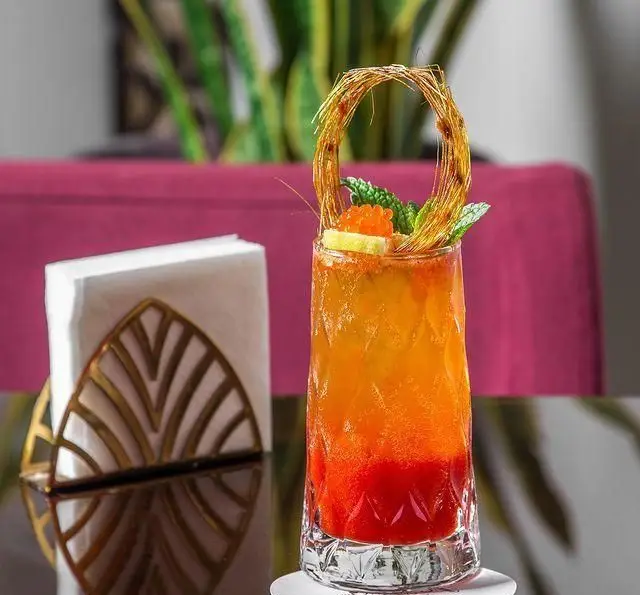 یک کوکتل میوه‌ای چندلایه و جذاب با تزیینات خلاقانه در کافه رستوران عربی مدائن، ایده‌آل برای تجربه‌ای متفاوت.