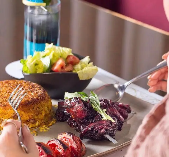 میز غذای دلپذیر در کافه رستوران عربی مدائن: کباب ویژه، برنج زعفرانی ته دیگ، سالاد فصل و نوشیدنی تازه. تجربه ای بی نظیر.