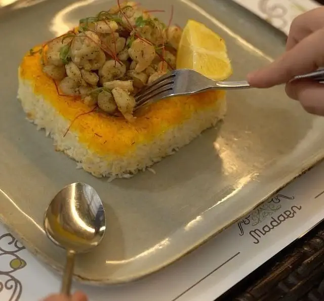 سینی میگو پلویی زعفرانی خاص کافه رستوران عربی مدائن. غذای دریایی اصیل با برنج زعفرانی و میگو تازه.