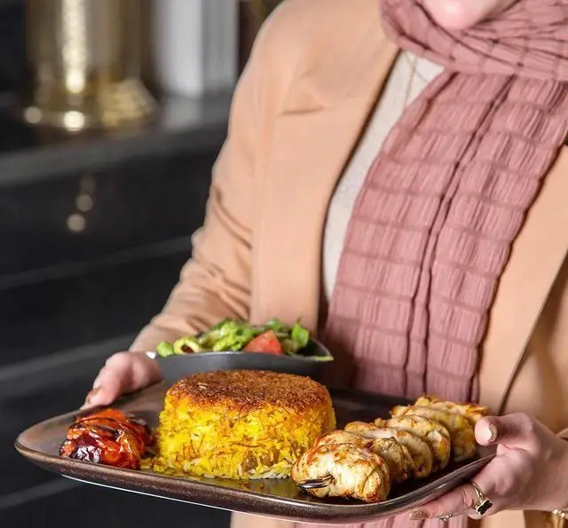 غذای مجلل کافه رستوران عربی مدائن: پلو زعفرانی و ته‌دیگ، مرغ گریل شده و سالاد تازه. لذت طعم اصیل و سنتی خاورمیانه.