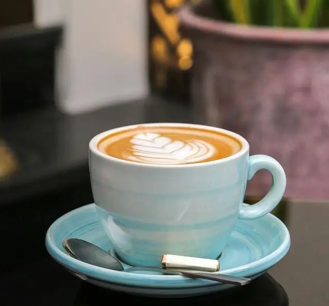 یک فنجان قهوه لاته خوشمزه با طرح قلب در کافه رستوران عربی مدائن، محیطی دلنشین برای استراحت و لذت از نوشیدنی.