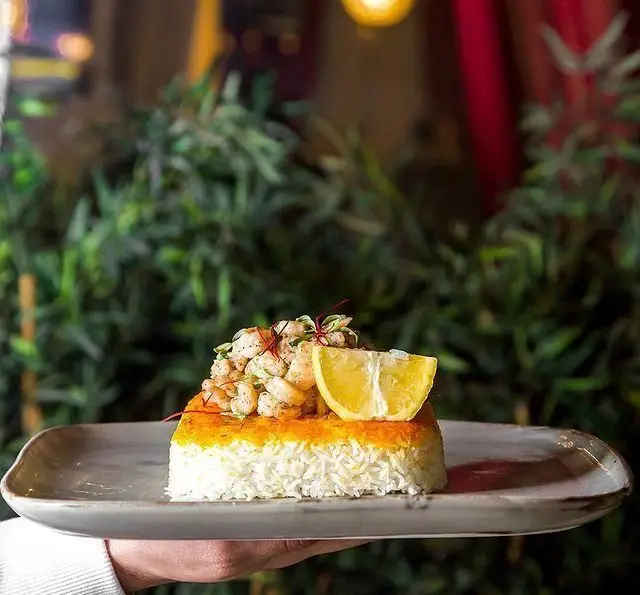 برنج قالبی زعفرانی و سفید با میگوهای تازه، لیمو و سبزیجات معطر؛ غذای لذیذ و دلپذیر از کافه رستوران عربی مدائن.