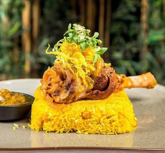 شاندیز لذیذ گوشت به همراه برنج زعفرانی قالبی و چاشنی در کافه رستوران عربی مدائن، تجربه‌ای اصیل از غذای عربی.