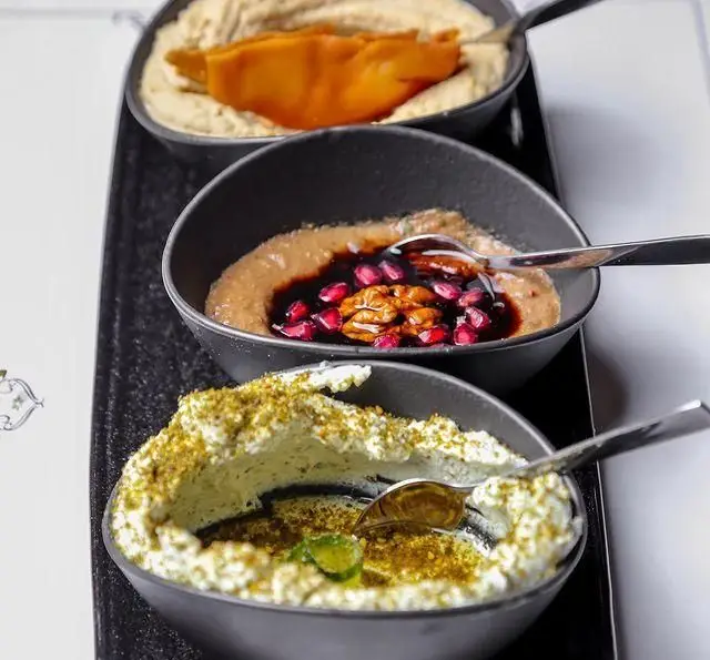 دیس مزه غذاهای عربی و مدیترانه‌ای کافه رستوران مدائن: حمص با کدو، دسر خرما و گردو با انار، و لبنه با پودر پسته و سبزیجات تازه.
