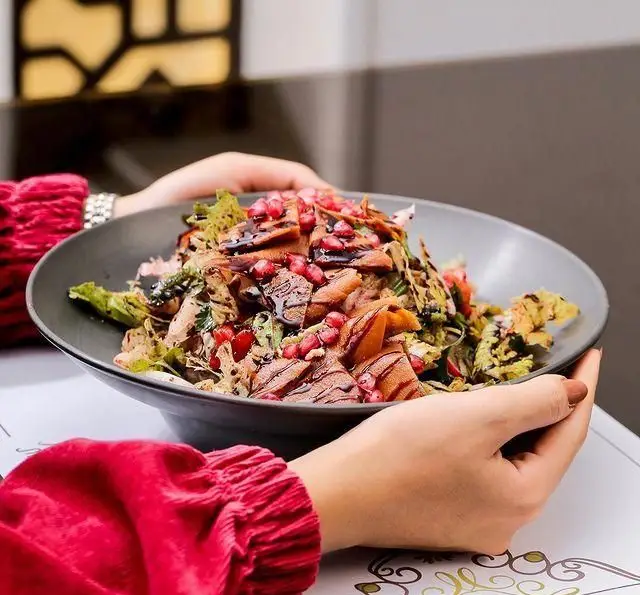 تصویری زیبا از سرو سالاد فتوح رنگارنگ با دانه انار و نان سرخ شده در کافه رستوران عربی مدائن، نشان دهنده کیفیت و طعم اصیل.