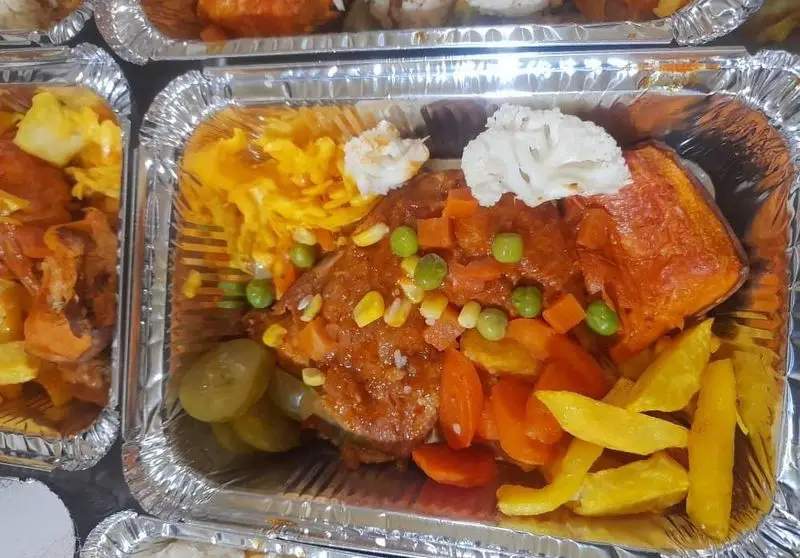 غذای کترینگ سالن پذیرایی یاس نیلوفری: وعده غذایی کامل و خوشمزه شامل خوراک مرغ یا ماهی، سیب زمینی، هویج، ذرت، نخود فرنگی و ترشی.