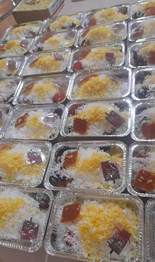 بسته‌بندی زیبای غذای آماده شامل برنج زعفرانی و خوراک‌های متنوع در ظروف آلومینیومی، مناسب سفارشات کترینگ و پذیرایی سالن یاس نیلوفری.