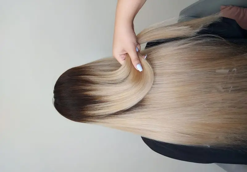 نمونه کار رنگ و لایت مو به سبک آمبره بلوند دودی طلایی با ریشه تیره روی موهای بلند و صاف در سالن زیبایی تخصصی آرایش