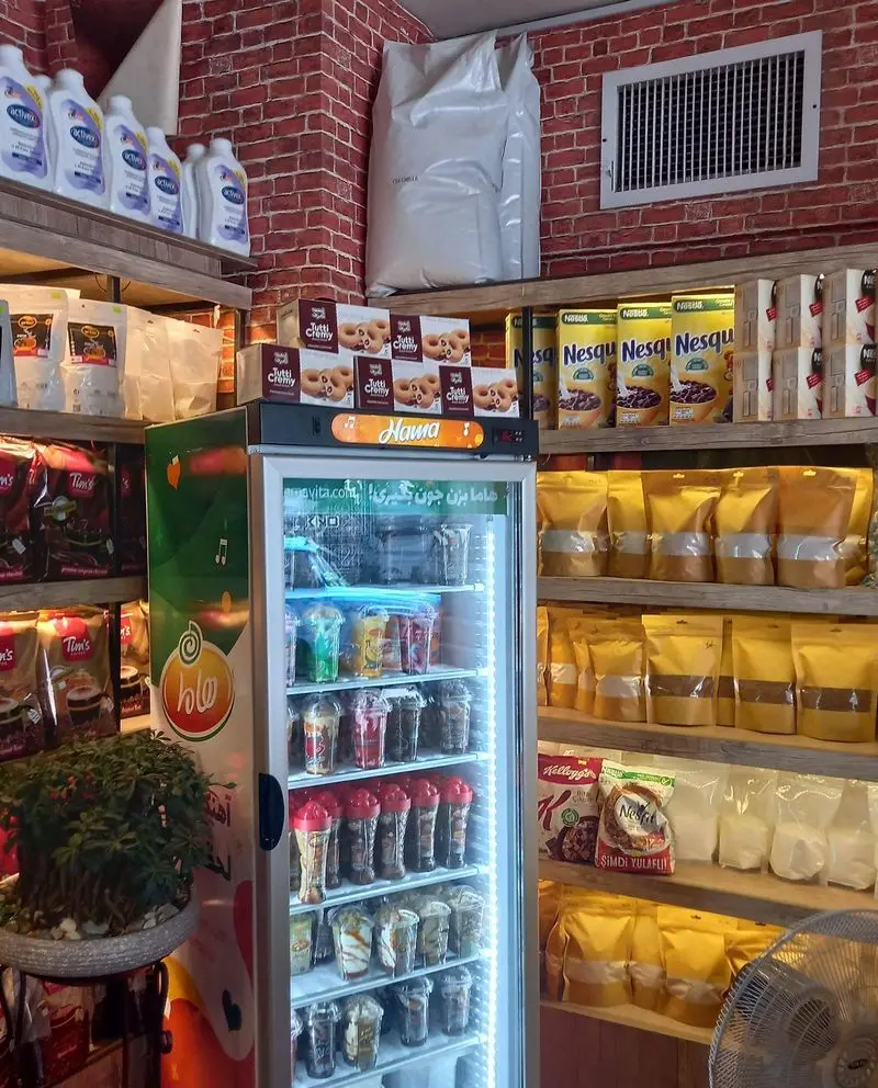 نمایی از قفسه‌های پر از محصولات قهوه، نوشیدنی، دسر و تنقلات در کسب و کار "قهوه کافی لند". فضایی دلنشین و متنوع.