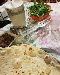 سفره سنتی و دلنشین ایرانی در باغ رستوران نور: نان تازه، سبزی خوردن، دوغ خنک و غذای محلی لذیذ برای تجربه ای اصیل.