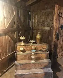 دکوراسیون داخلی سنتی و چشم‌نواز باغ رستوران نور، نمایش هنرمندانه ظروف برنزی عتیقه در محیطی چوبی و روستایی. فضایی دلنشین و اصیل.