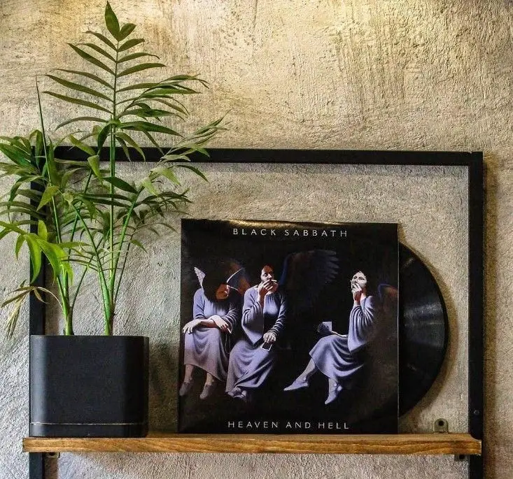 آلبوم وینیل بلک سبث Heaven and Hell به همراه یک گلدان شیک و گیاه سبز، بخشی از دکوراسیون خاص گات کافه.