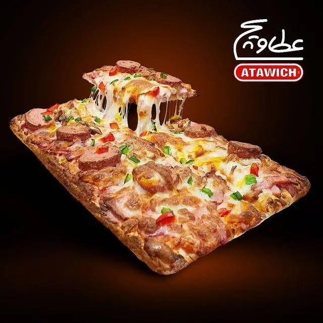 پیتزا مستطیلی عطاویچ با پنیر کشدار و سوسیس و کالباس، نمایی اشتهاآور از یک غذای خوشمزه و پرطرفدار آماده سرو در عطاویچ.