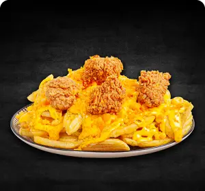 یک بشقاب پر از سیب‌زمینی سوخاری طلایی با سس پنیر چدار و تکه‌های مرغ سوخاری راسپر، غذای محبوب فست‌فود سوخاری راسپر.