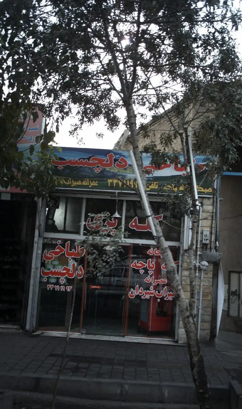 تصویر نمای بیرونی طباخی دلچسب در یک خیابان شهر، ارائه‌دهنده کله پاچه، سیراب و شیردان تازه. تلفن 33771994 و 33771993.