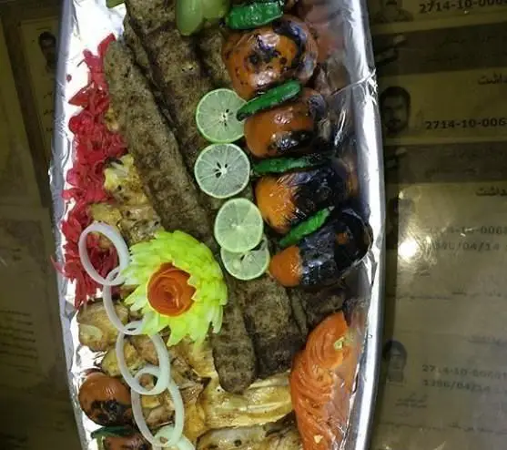 سینی شاهانه انواع کباب ایرانی شامل کوبیده، جوجه و ماهی با گوجه گریل و لیمو ترش تازه از کبابی خانه کباب.