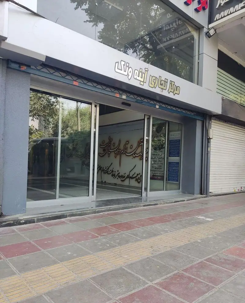 تصویر نمای خارجی کافه مانژه، واقع در مرکز تجاری آینه ونک، با ورودی شیشه‌ای، تابلوی اصلی و پیاده‌رو سنگی زیبا در پیش‌زمینه.