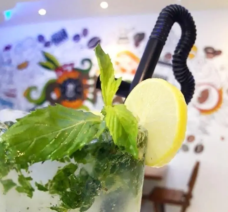 موهیتوی تازه و خنک با نعناع و لیمو در کافه مانژه. نوشیدنی دلچسب و تابستانی برای لحظاتی دلپذیر در کافه.