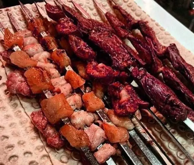 سیخ‌های کباب و جگر تازه و خوشمزه از کبابی جگرکی مزه، آماده سرو با نان داغ. تجربه‌ای لذیذ از غذای سنتی ایرانی.