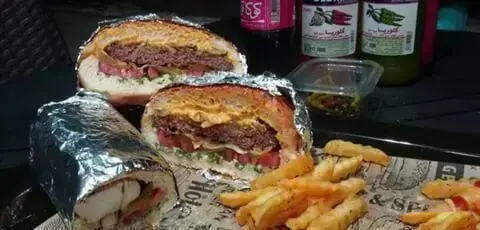 سفارش غذای خوشمزه از برگر ارگانیک برگر: شامل دو نیمه همبرگر بزرگ آبدار، یک ساندویچ رول کامل و سیب‌زمینی سرخ‌کرده کریسپی.