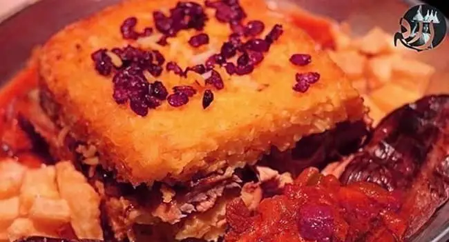 تصویر ته‌چین مرغ یا گوشت خوشمزه و زعفرانی مطبخ راد با ته‌دیگ طلایی و تزئین زرشک، آماده برای سفارش غذای ایرانی باکیفیت و سنتی.