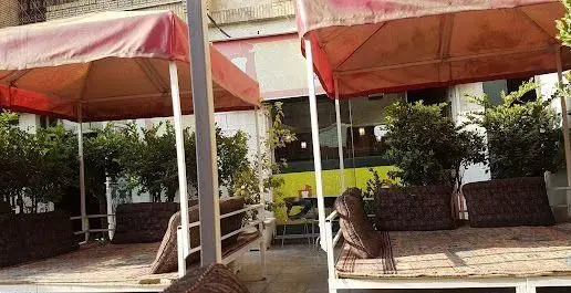 فضای باز دنج رستوران سنتی مستر دیزی شعبه میرداماد با تخت های چوبی و سنتی، ایده آل برای صرف دیزی و دورهمی ها.