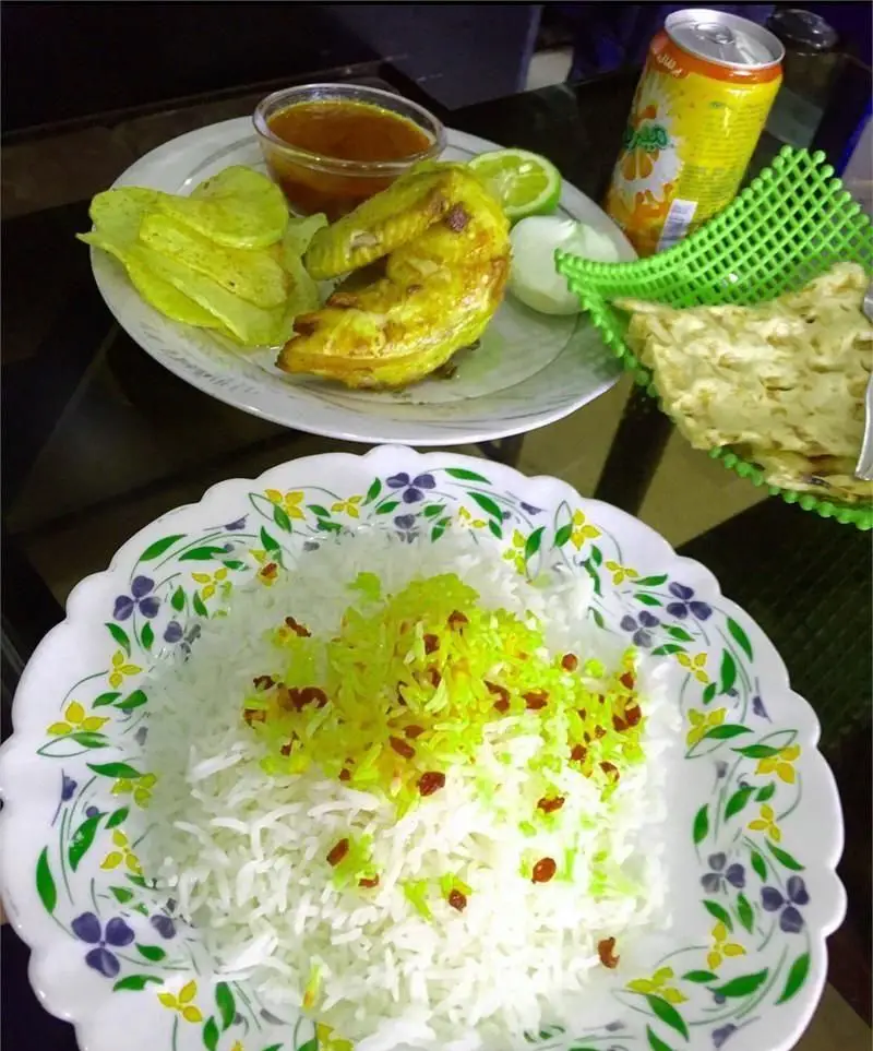 غذای خوشمزه رستوران ایرانی غذاکده طوس: زرشک پلو با مرغ کبابی، چیپس، نان تازه و نوشیدنی. تجربه‌ی اصیل غذای ایرانی.