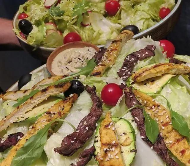 دو کاسه سالاد تازه و سالم کافی شاپ پرسیس. شامل مرغ و گوشت گریل، کدو، گوجه، زیتون و سس. انتخابی عالی برای وعده‌ای مقوی.