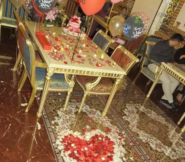 فضای خاص کافی شاپ پرسیس با تزیین رمانتیک شامل کیک تولد، بادکنک و گلبرگ‌های قلبی برای جشن تولد و سالگردها.