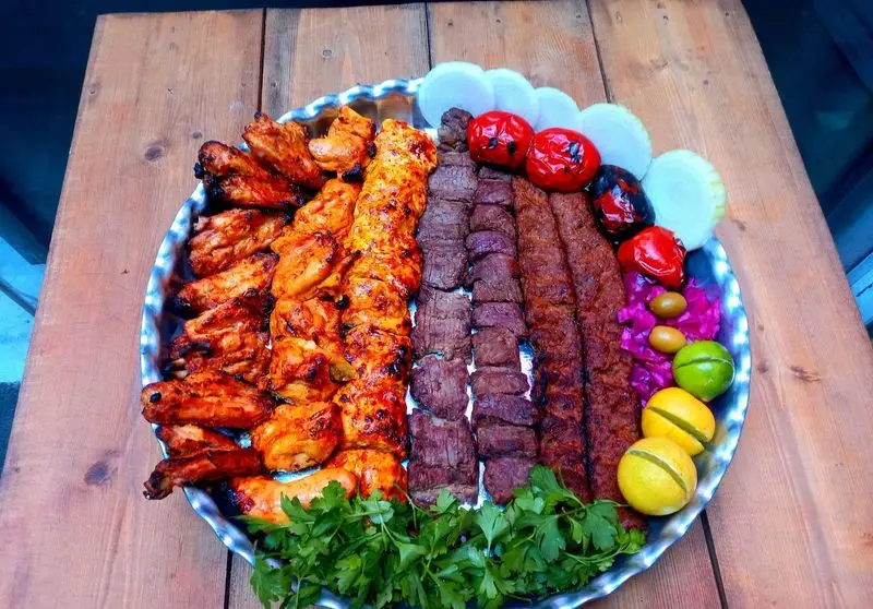 سینی بزرگ کباب میکس کبابسرای عشاق: جوجه بال، جوجه، کوبیده و برگ با گوجه کبابی، پیاز، ترشی، زیتون، لیمو و سبزی تازه.