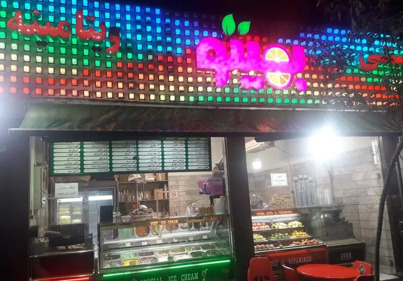 تصویر شب از ویتامینه بهیتو، مرکز آبمیوه و بستنی با تابلو LED پرنور، عرضه میوه تازه، انواع آبمیوه و دسرهای خنک.